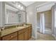 Well-lit bathroom with a granite countertop, decorative mirror, and a shower/tub combo at 7652 Whisper Way # 301, Reunion, FL 34747