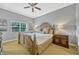Bedroom showcasing a ceiling fan, decorative pillows, side tables, and a window at 7652 Whisper Way # 301, Reunion, FL 34747