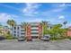 Three-story condo building with brick accents, balconies, and lush tropical landscaping at 7652 Whisper Way # 301, Reunion, FL 34747