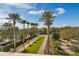 Beautifully landscaped walkway lined with palm trees and manicured hedges, enhancing the property's curb appeal at 7652 Whisper Way # 301, Reunion, FL 34747