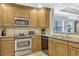 Kitchen featuring stainless steel appliances, tile backsplash, and wood cabinets at 7652 Whisper Way # 301, Reunion, FL 34747