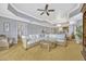 Spacious living room with wicker furniture, ceiling fan, tray ceiling, and an open floor plan at 7652 Whisper Way # 301, Reunion, FL 34747
