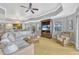 Bright living room features neutral walls, ceiling fan, entertainment center, and wicker furniture at 7652 Whisper Way # 301, Reunion, FL 34747