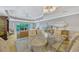 Open-concept living space with dining area, wicker furniture, and balcony access at 7652 Whisper Way # 301, Reunion, FL 34747