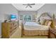 Bedroom showcasing a dresser with a TV, a ceiling fan, side tables, and a window at 7652 Whisper Way # 301, Reunion, FL 34747