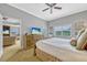 Spacious bedroom featuring a ceiling fan, dresser with TV, and view to the connected living room at 7652 Whisper Way # 301, Reunion, FL 34747