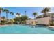 Refreshing pool area with palm trees and poolside lounge chairs, perfect for relaxation and outdoor enjoyment at 7652 Whisper Way # 301, Reunion, FL 34747