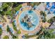 Aerial view of an amazing water park with a lazy river and lounge chairs under blue umbrellas, surrounded by lush greenery at 7652 Whisper Way # 301, Reunion, FL 34747