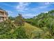 Building exterior view with lush landscaping, mature trees, and vibrant blue sky at 7652 Whisper Way # 301, Reunion, FL 34747