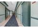 Long hallway with access to multiple units, featuring tile floors, neutral walls, and a blue carpet for noise reduction at 800 N Atlantic Ave # 417, Daytona Beach, FL 32118