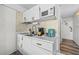 Efficient kitchen with white cabinets, modern microwave, gold hardware and backsplash, perfect for quick meal preparation at 800 N Atlantic Ave # 417, Daytona Beach, FL 32118