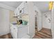 Cozy kitchen featuring white cabinetry, modern appliances, and unique gold backsplash, leading to the bathroom at 800 N Atlantic Ave # 417, Daytona Beach, FL 32118