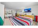 Living area featuring a flat-screen TV, colorful striped bedding, and a kitchenette, perfect for relaxing and entertaining at 800 N Atlantic Ave # 417, Daytona Beach, FL 32118