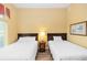 This bedroom features wood-look floors, two cozy beds with matching wood frames, and an inviting color scheme at 8100 Poinciana Blvd # 2109, Orlando, FL 32821