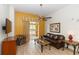 Bright living area featuring sleek wood floors, complemented by a ceiling fan and sliding glass doors to the balcony at 8100 Poinciana Blvd # 2109, Orlando, FL 32821