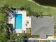 Aerial view of community pool with lounge chairs, tables, and lush landscaping around the area at 902 Wingate Trl, Port Orange, FL 32128