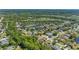 This aerial captures a neighborhood with beautiful homes, serene ponds, and lush, mature trees at 902 Wingate Trl, Port Orange, FL 32128