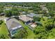 This aerial shot shows a home with a brick patio, and a screened-in pool, in a lush neighborhood at 902 Wingate Trl, Port Orange, FL 32128