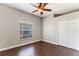 Spacious bedroom with hardwood floors, a window letting in natural light, and a double door closet at 902 Wingate Trl, Port Orange, FL 32128