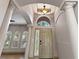 Grand foyer with soaring ceilings, tile flooring, a decorative column, and an arched window above the front door at 902 Wingate Trl, Port Orange, FL 32128