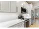 A close up of the kitchen featuring stainless steel appliances, white cabinets, and a quartz countertop at 902 Wingate Trl, Port Orange, FL 32128