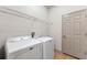 Functional laundry room featuring a washer, dryer, tile floors, and storage shelves for organization at 902 Wingate Trl, Port Orange, FL 32128