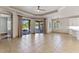 Open living room with tile flooring, ample natural light from sliding glass doors, and a modern ceiling fan at 902 Wingate Trl, Port Orange, FL 32128