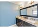A blue bathroom offers a spacious vanity with granite countertop and updated light fixtures at 9338 Palm Tree Dr, Windermere, FL 34786
