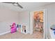 Bedroom with a ceiling fan, play kitchen, shelves, and a closet full of toys and storage at 9338 Palm Tree Dr, Windermere, FL 34786