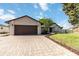 Beautiful home featuring a brick paved driveway, two-car garage, manicured lawn, and mature trees at 9338 Palm Tree Dr, Windermere, FL 34786