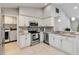 Well-equipped kitchen with stainless appliances, white cabinets, and a view of the laundry area at 9338 Palm Tree Dr, Windermere, FL 34786