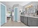 Well lit bathroom with double sinks and gray cabinets leading to a bedroom at 1004 Moccasin Run Rd, Oviedo, FL 32765