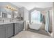 Elegant bathroom featuring a standalone tub, double vanity sinks and stylish lighting at 1004 Moccasin Run Rd, Oviedo, FL 32765