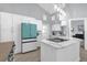 Bright kitchen featuring a unique turquoise refrigerator and an island with cooktop at 1004 Moccasin Run Rd, Oviedo, FL 32765