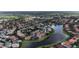 An aerial view of a neighborhood bordering a lake with lush greenery and well-maintained homes at 1027 Algare Loop, Windermere, FL 34786