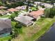 An aerial view of a home with a gray roof, lake frontage, and a well-manicured lawn at 1027 Algare Loop, Windermere, FL 34786