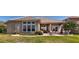 Brick paved lanai with outdoor seating area overlooks a backyard with lush green lawn, and water views beyond at 1027 Algare Loop, Windermere, FL 34786