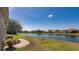 Tranquil lakeside view from the backyard, featuring a brick-paved walkway, lush greenery, and picturesque scenery at 1027 Algare Loop, Windermere, FL 34786