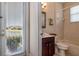 Bright bathroom featuring a cherry vanity and a tub with tile surround and a window view to the outdoors at 1027 Algare Loop, Windermere, FL 34786