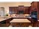 Elegant kitchen with dark wood cabinets, stainless appliances, and center island at 1027 Algare Loop, Windermere, FL 34786