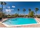 Beautiful outdoor pool with palm trees, lounge chairs, and a lake view on a sunny day at 1027 Algare Loop, Windermere, FL 34786