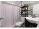 Bathroom with patterned shower curtain, dark vanity and open shelf at 1034 Featherstone Cir, Ocoee, FL 34761
