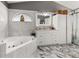 Luxurious bathroom featuring a soaking tub, marble-tiled walls, and a modern vanity at 1034 Featherstone Cir, Ocoee, FL 34761