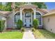 Elegant home entrance boasting decorative pillars and arched windows, enhanced by vibrant landscaping at 1034 Featherstone Cir, Ocoee, FL 34761
