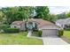 Charming single-story home with manicured lawn, mature trees, and a well-maintained exterior, offering a welcoming curb appeal at 1034 Featherstone Cir, Ocoee, FL 34761