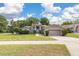 Inviting single-story home with a well-maintained lawn and garden beds, showcasing its charming curb appeal at 1034 Featherstone Cir, Ocoee, FL 34761