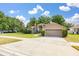 Attractive single-story home featuring manicured landscaping, healthy green lawn, and a convenient two-car garage at 1034 Featherstone Cir, Ocoee, FL 34761