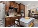 Modern kitchen with stainless steel appliances, dark wood cabinets, and stylish backsplash at 1034 Featherstone Cir, Ocoee, FL 34761