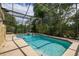 Screened-in pool with spa and lush landscaping creates a private backyard oasis at 1034 Featherstone Cir, Ocoee, FL 34761