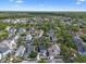 An aerial view showcases a vibrant community with lush greenery and well-maintained homes under a sunny sky at 109 Grinnell Pl, Celebration, FL 34747